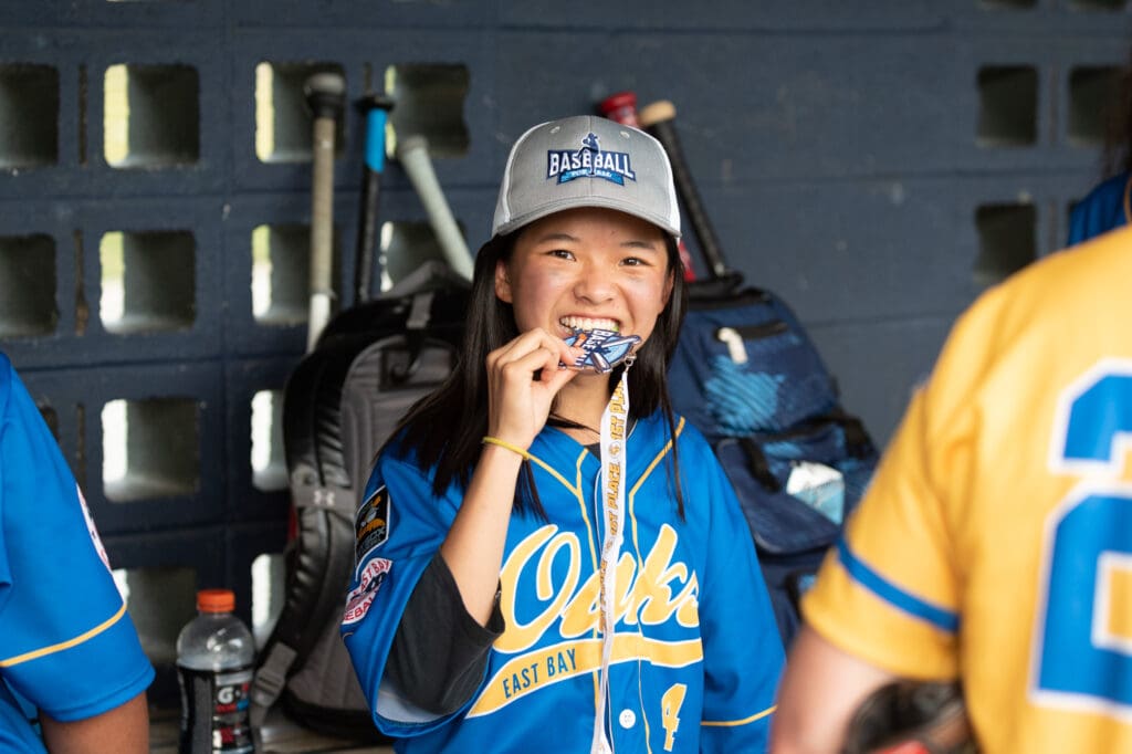 Baseball For All player with championship medal